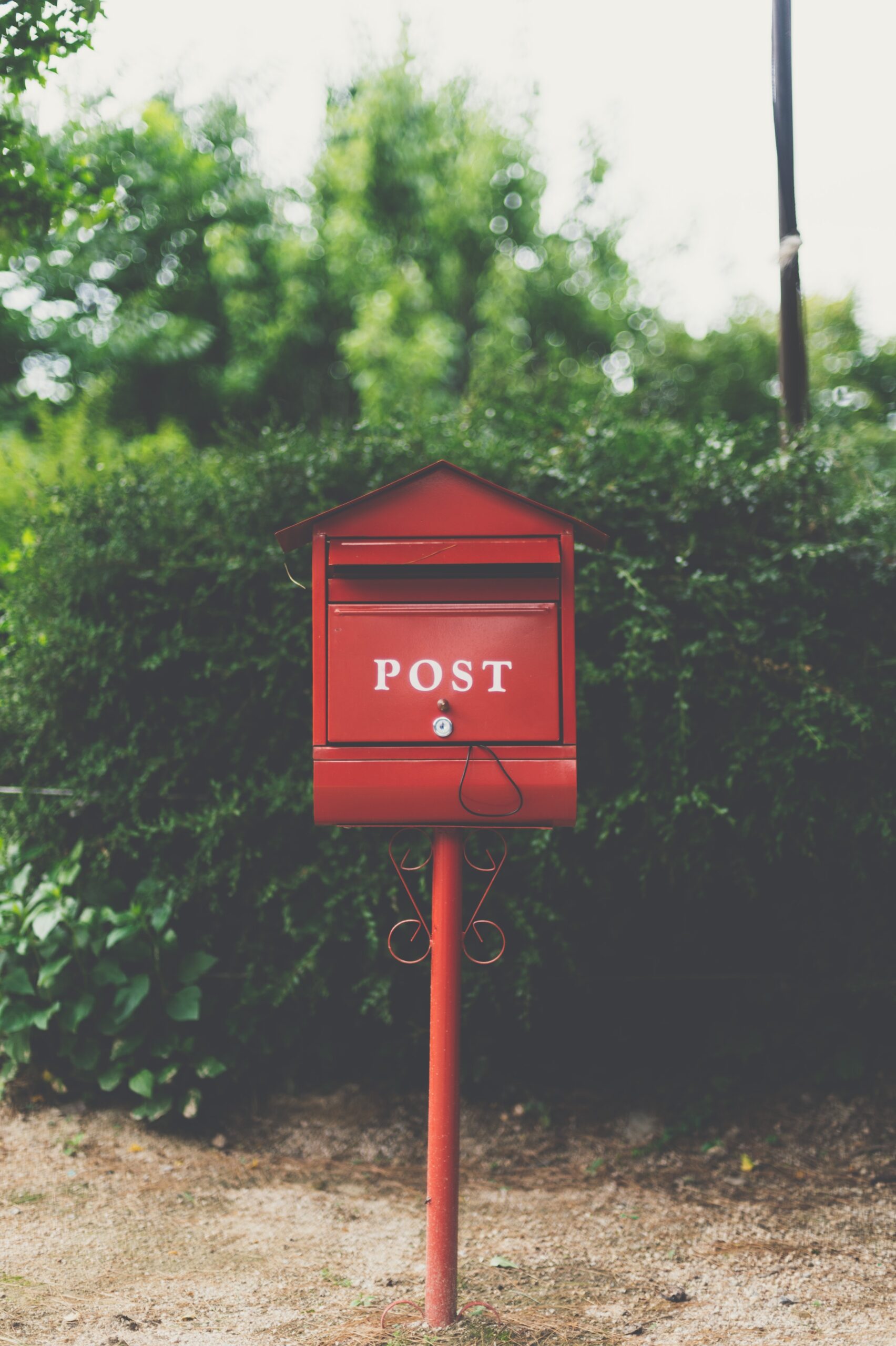 A red postal letterbox surrounded by greenery